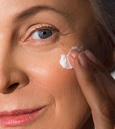 viso di donna che utilizza la crema intorno all'occhio